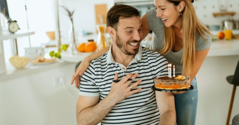 אישה שמפתיעה את בעלה עם עוגה ביום הולדתו